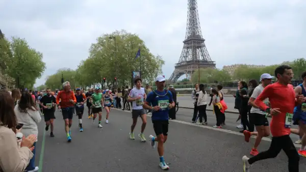 Corredores participan en el maratón de París, con la Torre Eiffel como telón de fondo.