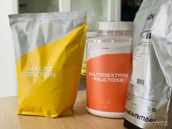 Bolsas y bote de suplementos deportivos con "Maltodextrin" y "Maltodextrin + Fructose". Aunque la maltodextrina es mala para algunos, aquí se presenta como opción.
