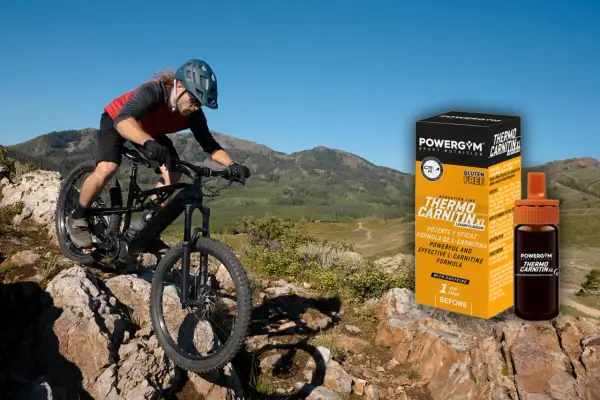 Ciclista de montaña desciende por terreno rocoso. A su lado, caja y vial de Powergym Thermo Carnitina XL, para saber como tomar l carnitina.