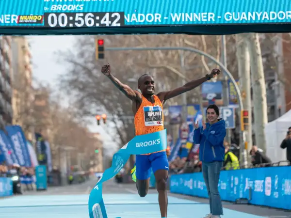Atleta cruza la meta, celebrando su victoria y un posible récord de 1500 metros. El cronómetro marca 00:56:42.