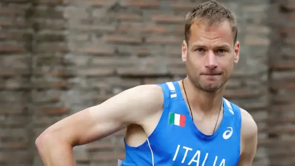 Alex Schwazer, atleta italiano, con la bandiera italiana sul petto.